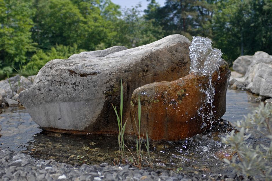 Ein Quellstein in Garten Findling.ch Steine für Gärten